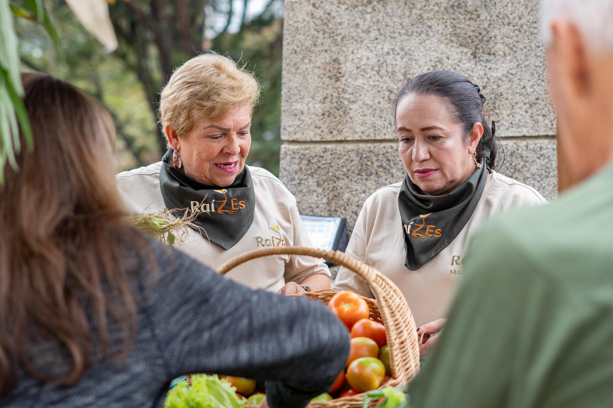 Mujeres de ASOMUF compartiendo la cosecha en el mercado de Fredonia